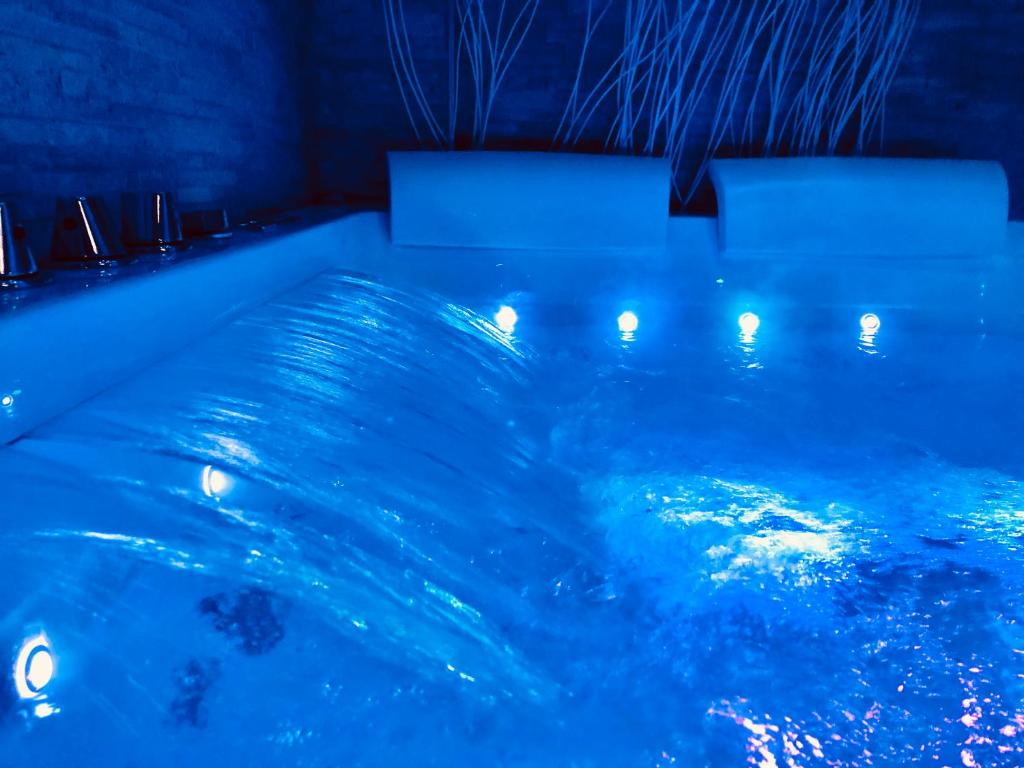 梅塔YourHome - La Meta Perfetta Rooms&Spa的游泳池里拥有蓝色的水和灯光