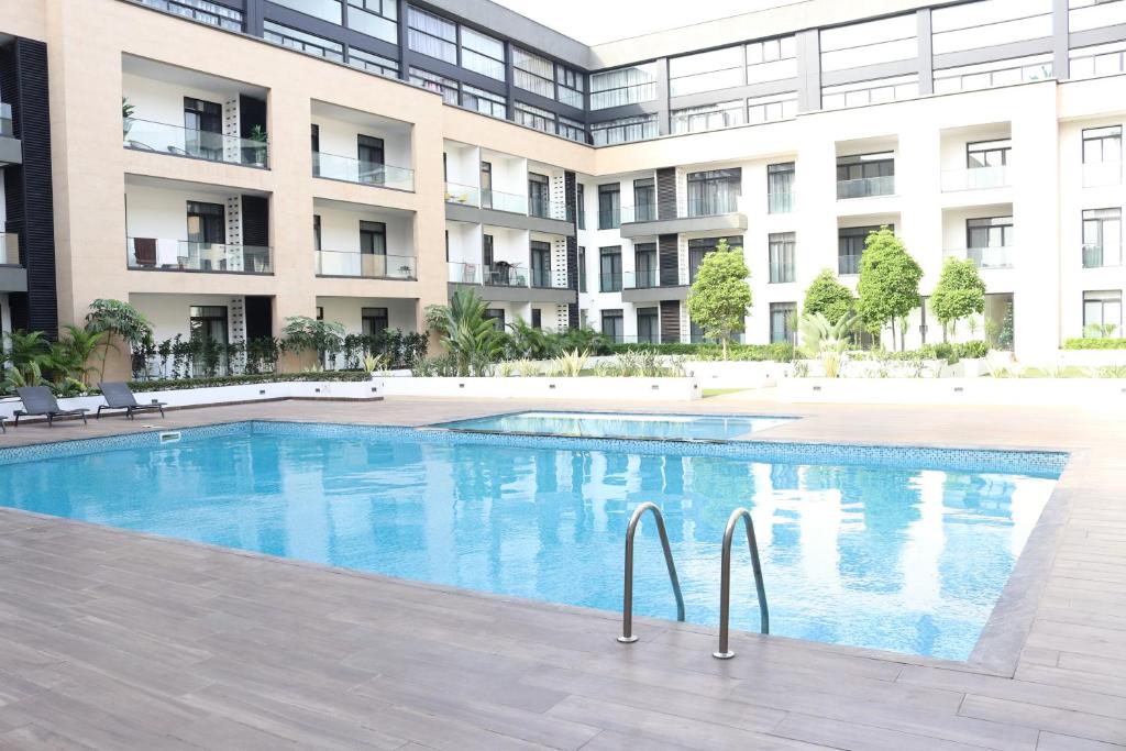 阿克拉APARTMENTS GH - Accra - Cantonments - Embassy Gardens的大楼前的游泳池