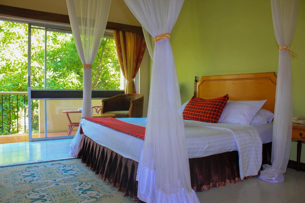 阿鲁沙赤道酒店的一间卧室配有一张带蚊帐的床
