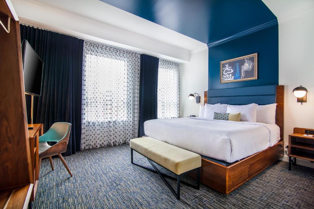 温哥华Hotel Belmont Vancouver MGallery的酒店客房设有一张大床和一台电视。