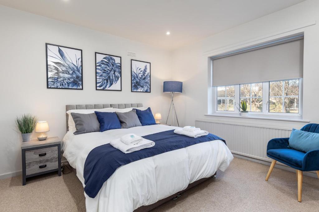 谢菲尔德Cosy, Exclusive, Sheffield House near Peak District by Ark SA的一间卧室配有一张大床和一张蓝色椅子