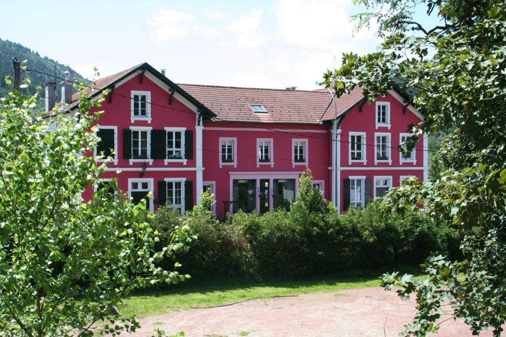 科尔尼蒙米拉贝尔度假屋的前面有灌木丛的大红房子