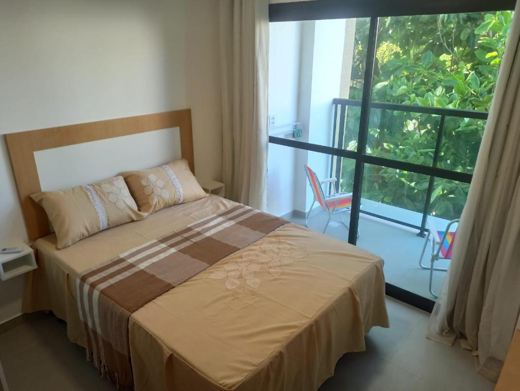 嘎林海斯港Flat Macaraípe - Maraca Beach I的一间卧室设有一张床和一个大窗户