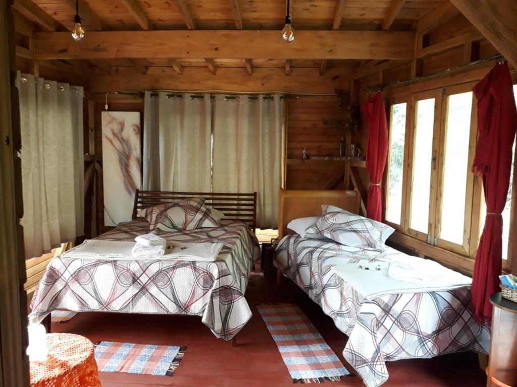 新彼得罗波利斯Eco Aldeia的小木屋内一间卧室,配有两张床