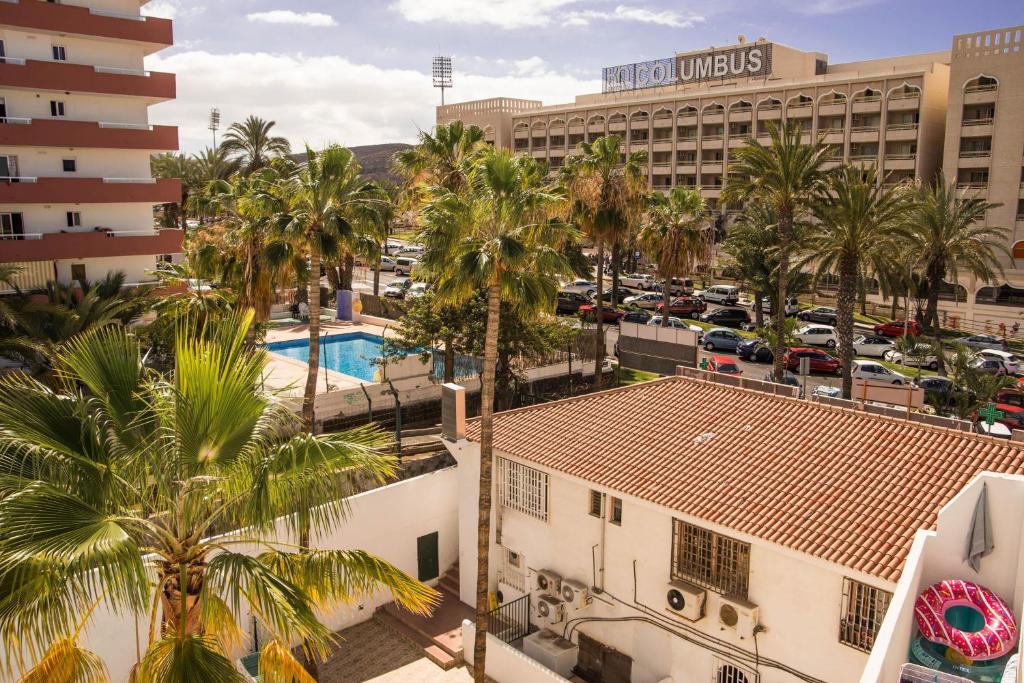 阿罗纳Best centric location for stay LA81的享有棕榈树酒店和停车场的空中景致