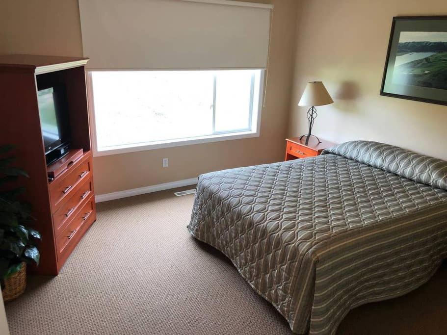 莱斯布里奇Paradise Canyon Golf Resort, Luxury Villa 407的一间卧室配有一张床、一台电视和一个窗口