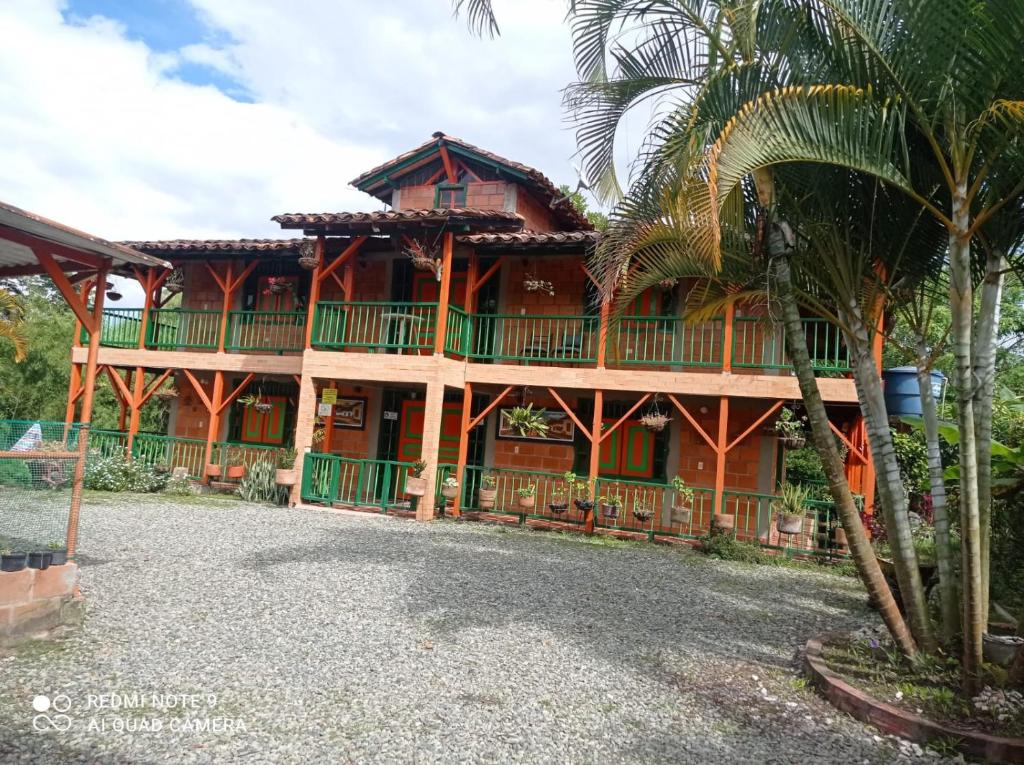 蒙特内哥罗Finca Hotel Villa Mariana的一座大型木屋,前面有棕榈树