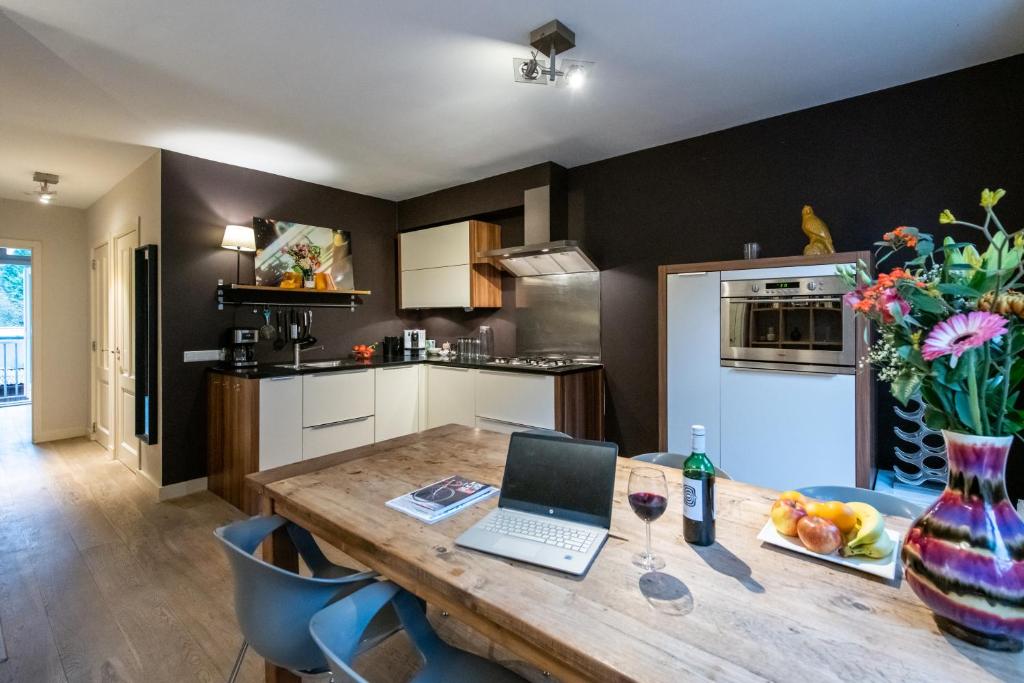 阿姆斯特丹Two-bedroom Apartment in Amsterdam West的厨房配有木桌和笔记本电脑