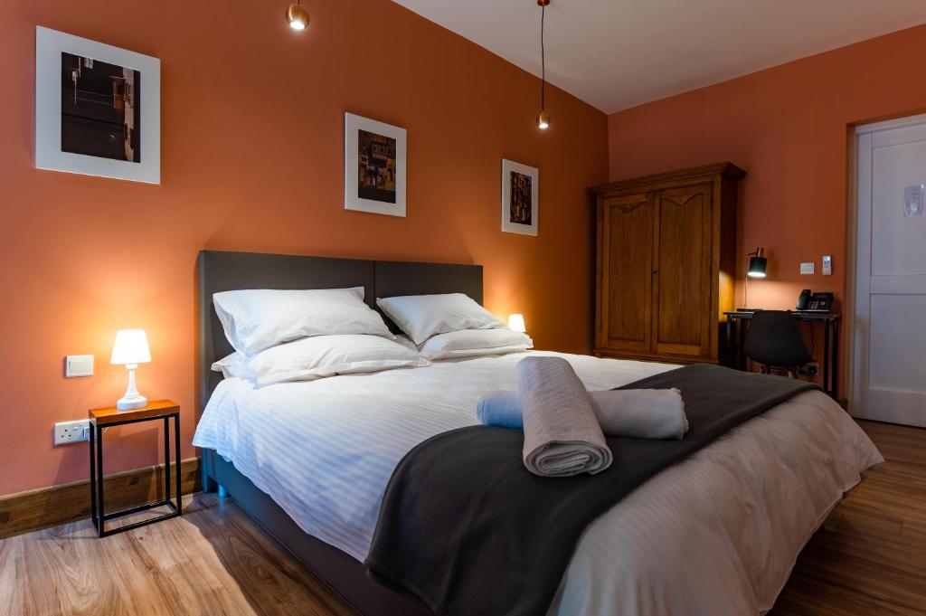 佩奥拉Monreal Boutique Townhouse - R024RM2的一间卧室配有一张带橙色墙壁的大床