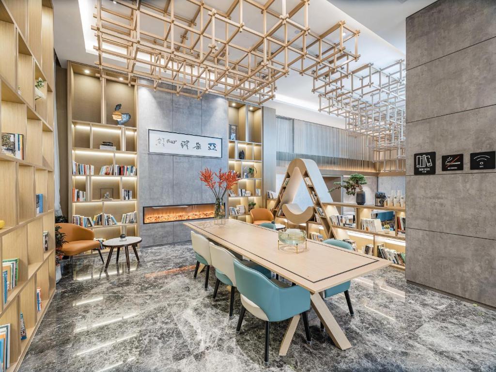 徐州徐州市政府亚朵酒店的配有桌椅和书架的房间