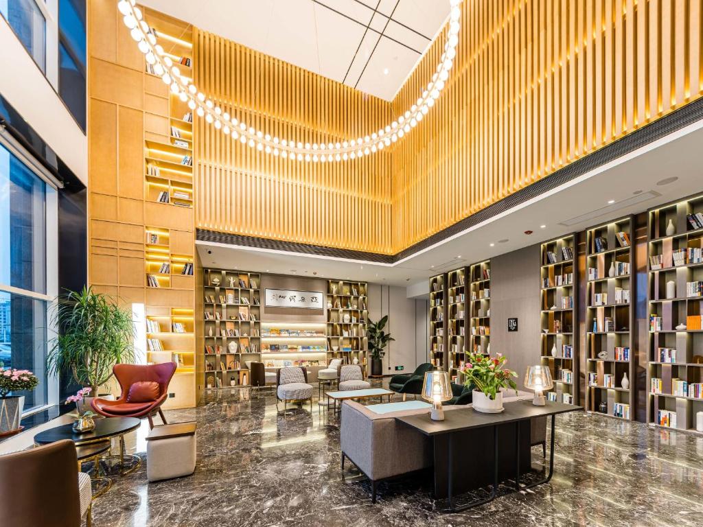 徐州徐州云龙CBD亚朵酒店的图书馆配有桌椅和书架