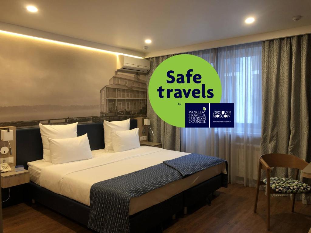 莫斯科伏尔加公寓酒店的一间卧室,配有一张床和一个安全旅行标志