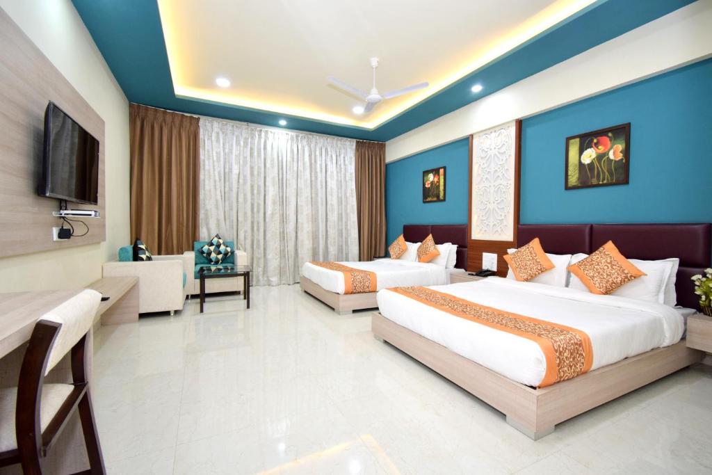 纳特杜瓦拉The Sky Imperial- Hotel Gopal Darshan的酒店客房设有两张床和电视。