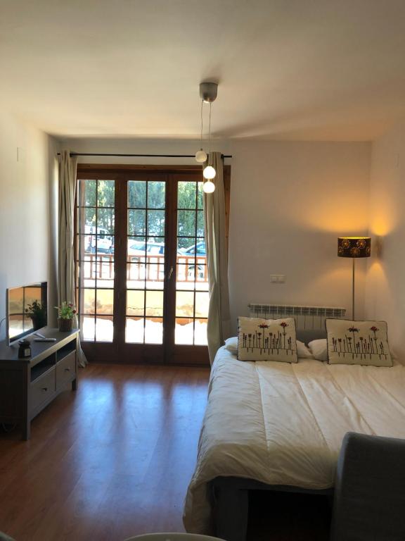 拉莫利纳Apartamento frente Pistas de Esquí La Molina的一间卧室设有一张床和一个大型滑动玻璃门