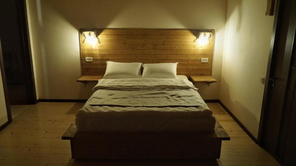 卡兹贝吉Mansarda Kazbegi的小房间设有一张大床,配有两个枕头