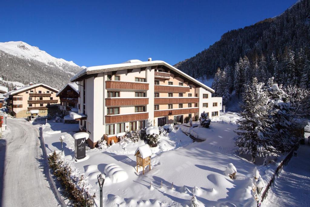 圣安东阿尔贝格"Quality Hosts Arlberg" Hotel Garni Mössmer的雪中大建筑
