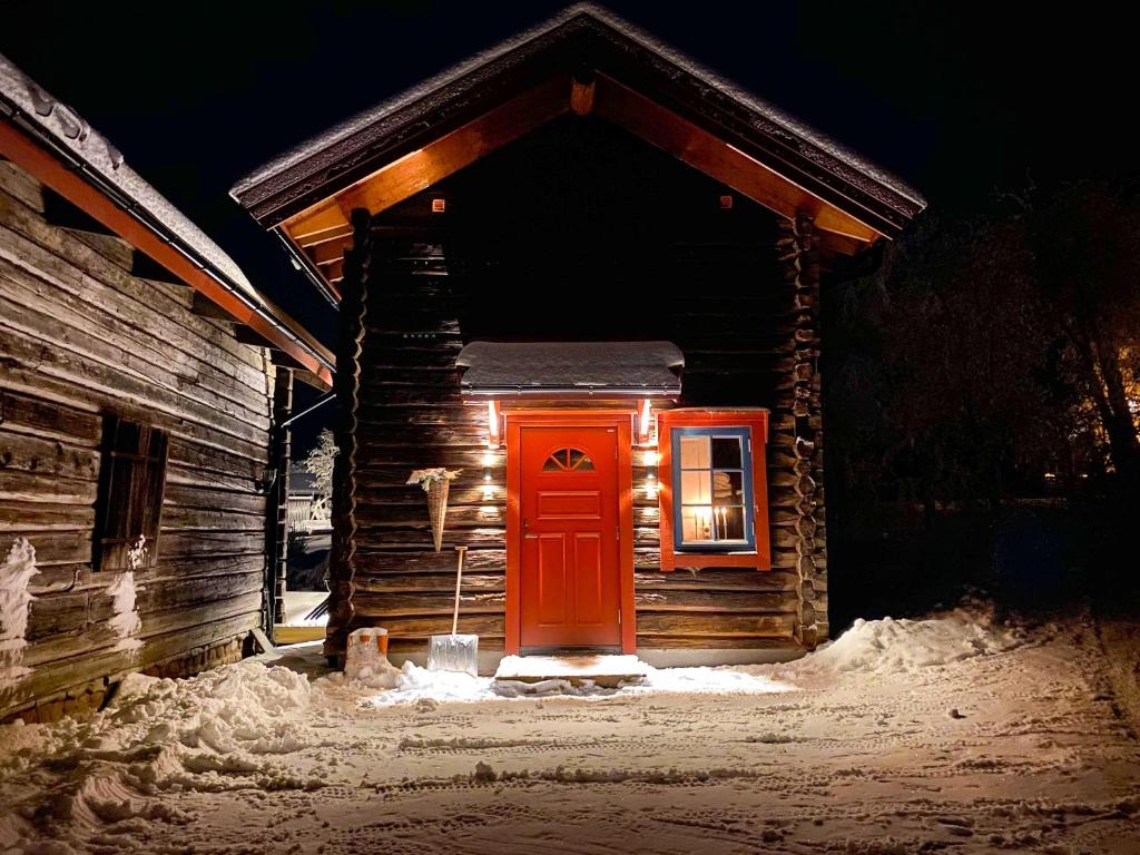 奥萨The Fryksås Chamber的雪中带红门的小小屋