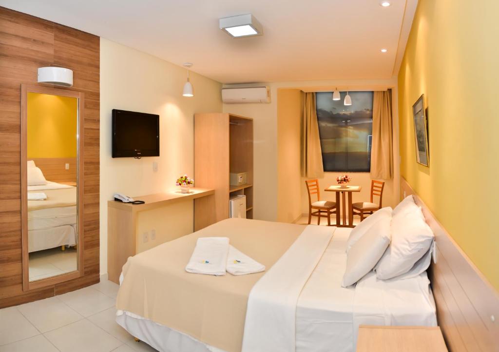 萨尔瓦多希特酒店的酒店客房设有一张床和一张小桌子。