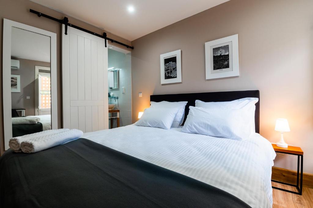 佩奥拉Monreal Boutique Townhouse - R024RM3的卧室配有带白色枕头的大床