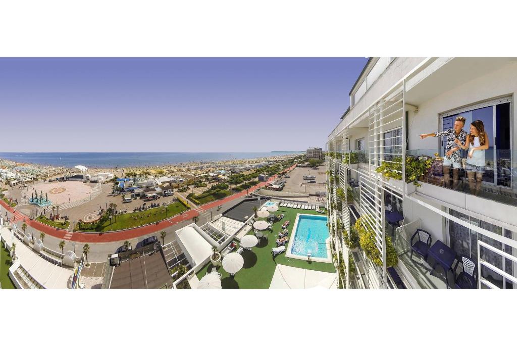 里乔内Hotel Mediterraneo的享有带游泳池和海滩的建筑景致