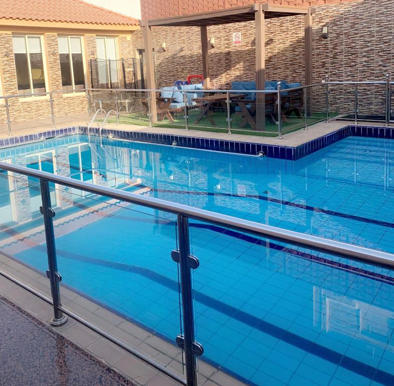 吉达جُمان للعائلات的一个带桌子的大型蓝色游泳池