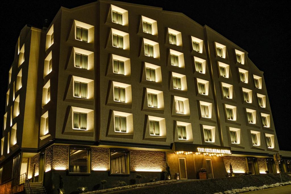 埃尔祖鲁姆The Erzurum Hotel的一座大型建筑,晚上有很多窗户
