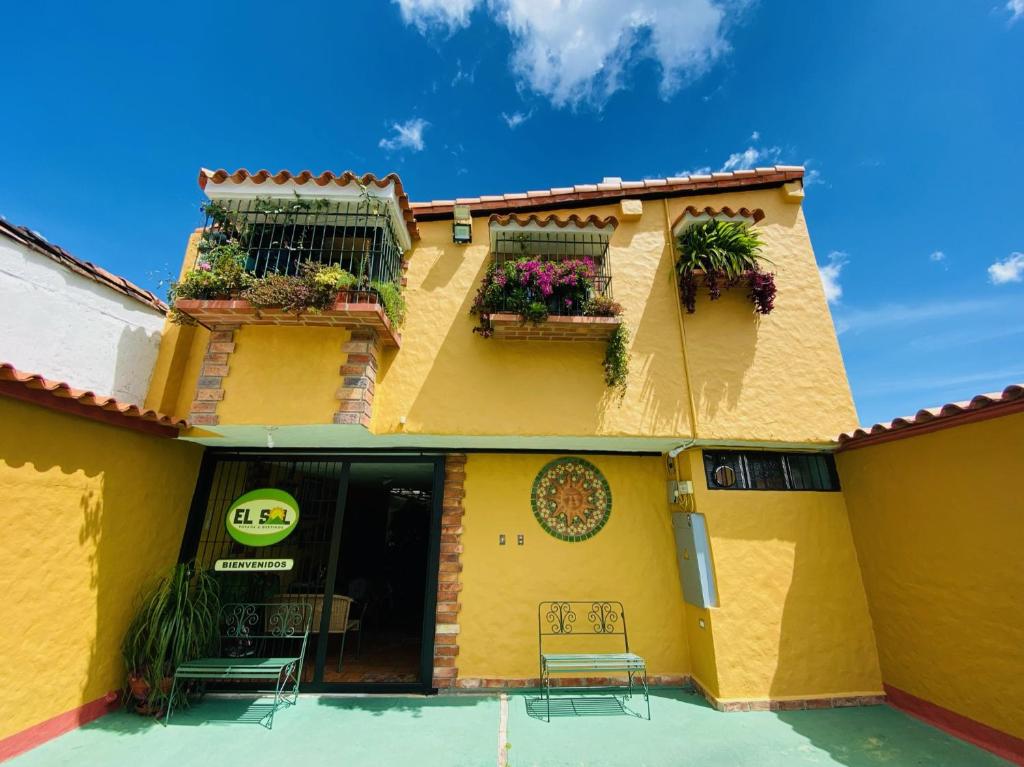 圣克里斯托瓦尔El Sol Posada的黄色的建筑,设有两个种有植物的阳台