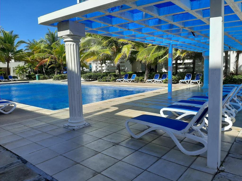 里奥阿托Relajate en un hermoso apartamento Duplex cerca de la playa y piscina en Playa Blanca, Farallon的一个带椅子的庭院和一个游泳池