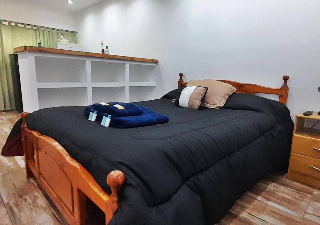 埃尔卡拉法特Departamento en El Calafate para dos personas的一间卧室配有一张大床和黑色棉被