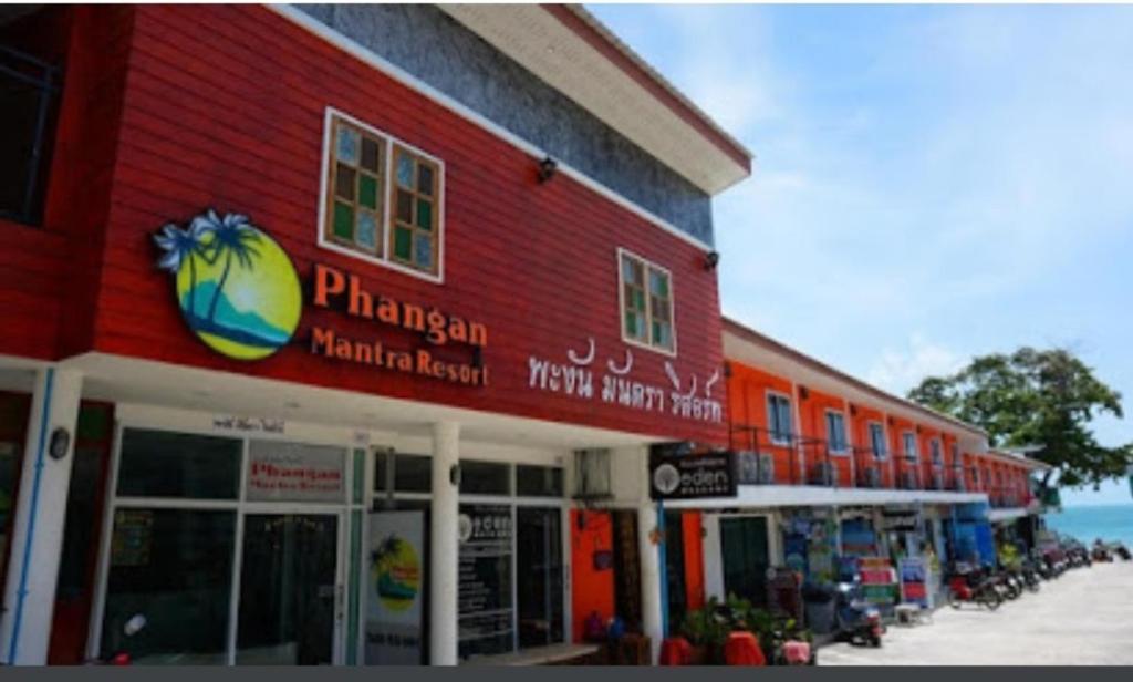 哈林海滩Phangan Mantra Inn的一面有标志的红色建筑