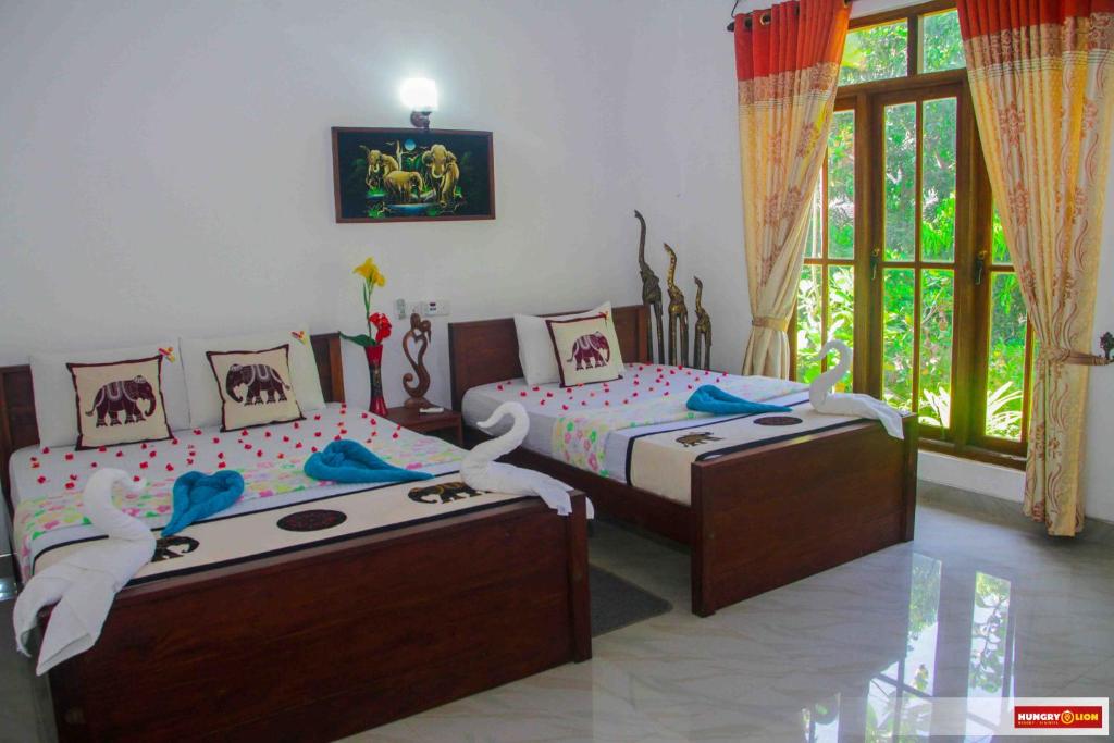 锡吉里亚Hungry Lion Resort的一间卧室设有两张床和窗户。