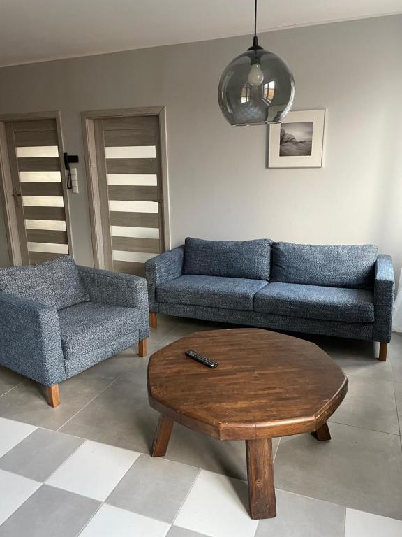 科莫尔尼基Apartamenty Komorniki的客厅配有2张蓝色沙发和1张咖啡桌