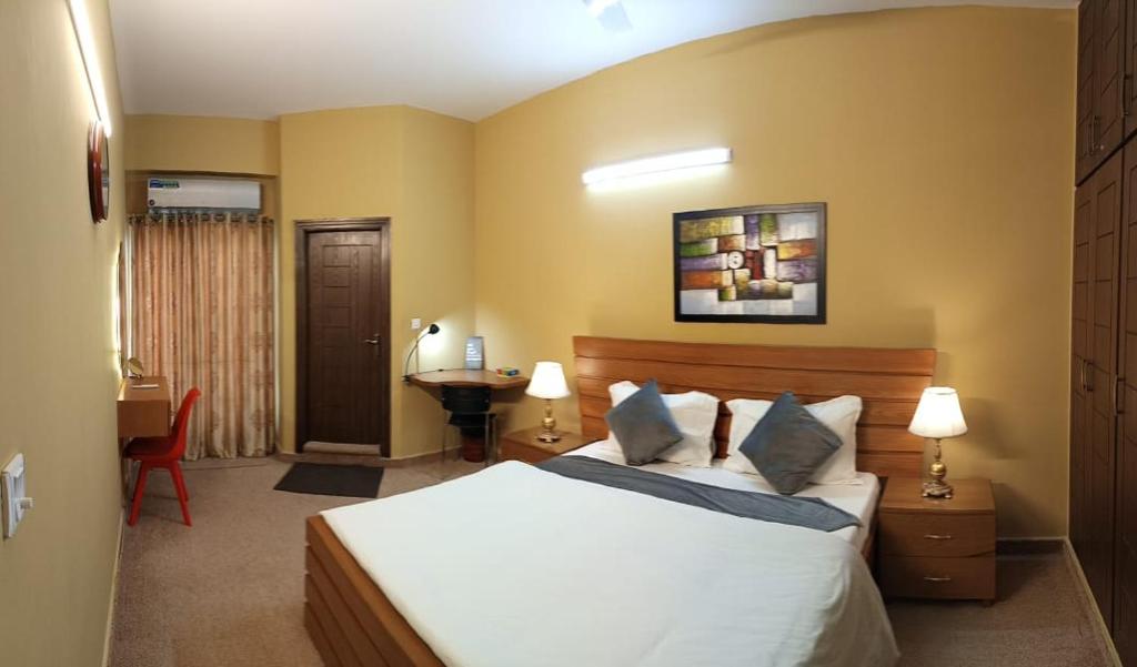 伊斯兰堡Tourist Inn Apartment的一间卧室配有一张床和一张书桌