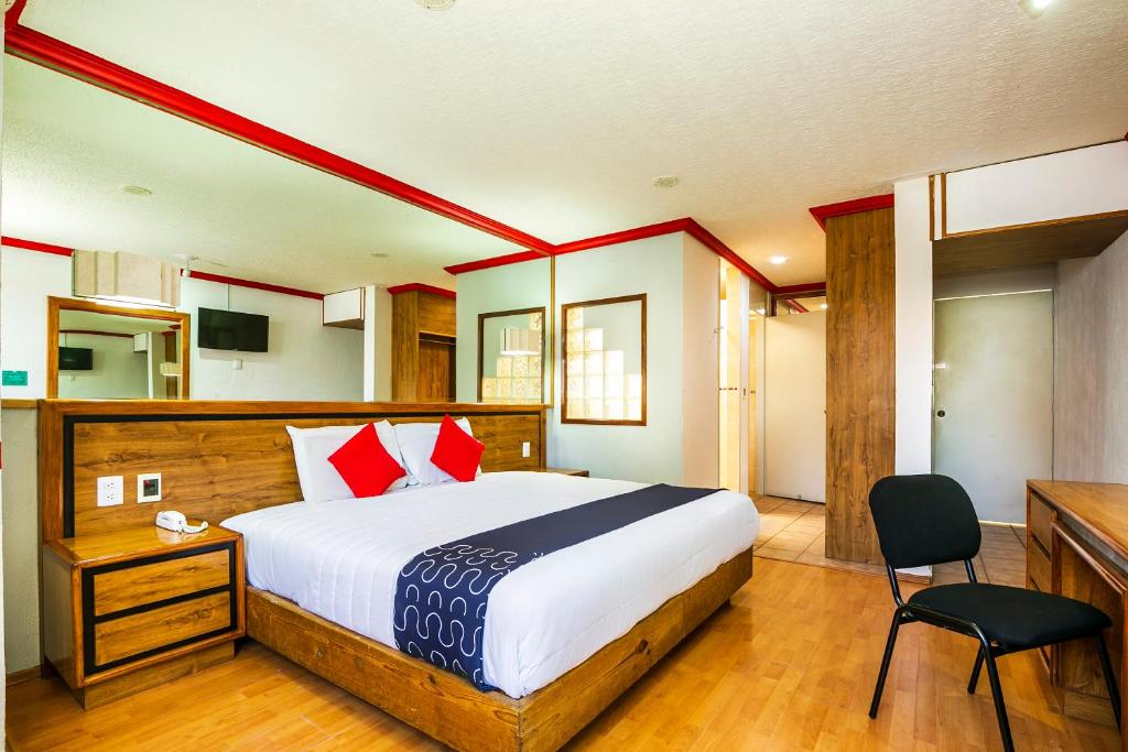 莫雷利亚Capital O Hotel Casa Blanca, Morelia的一间卧室配有一张带红色枕头的大床