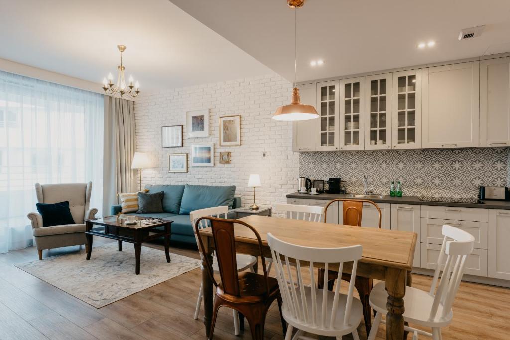 弗罗茨瓦夫EXCLUSIVE Aparthotel的厨房以及带桌子和沙发的客厅。