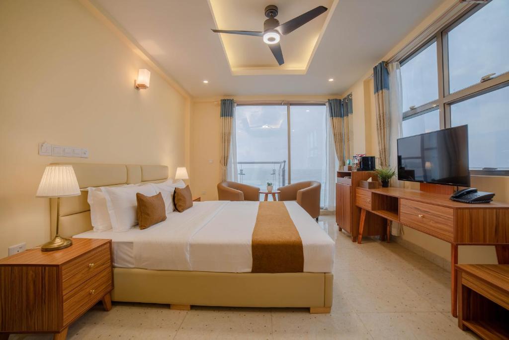 胡鲁马累Amber Beach Hotel的一间卧室配有一张大床和电视