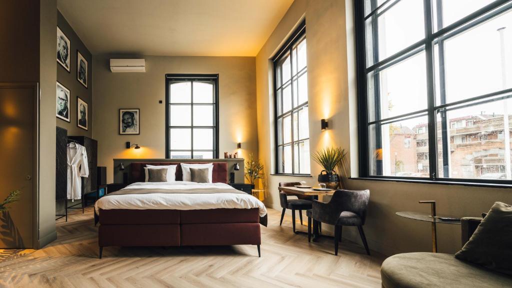 温特斯韦克Oldschool Hotel的卧室配有一张床、一张书桌和窗户。