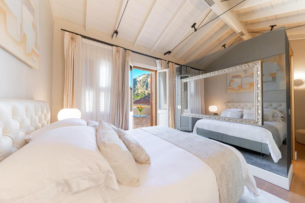 纳夫普利翁Castellano Hotel & Suites的一间卧室设有两张床和大窗户
