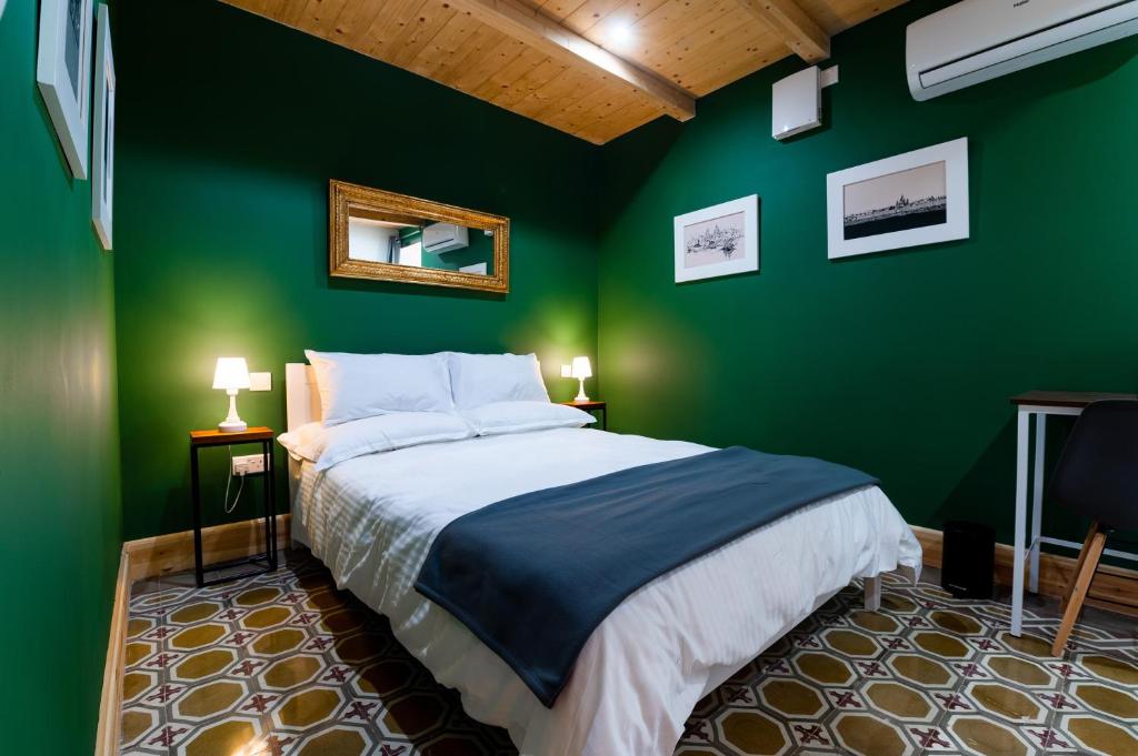 佩奥拉Monreal Boutique Townhouse - R024RM5的绿色卧室,配有床和绿色的墙壁