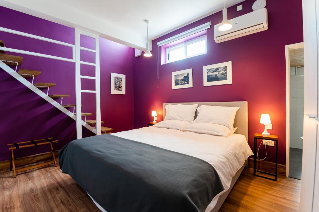 佩奥拉Monreal Boutique Townhouse - R024RM6的一间卧室配有一张床和紫色的墙壁