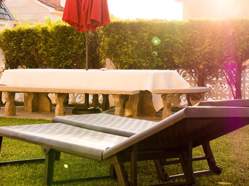 尼格兰Patos Beach - Garden的一张带桌子和雨伞的野餐桌