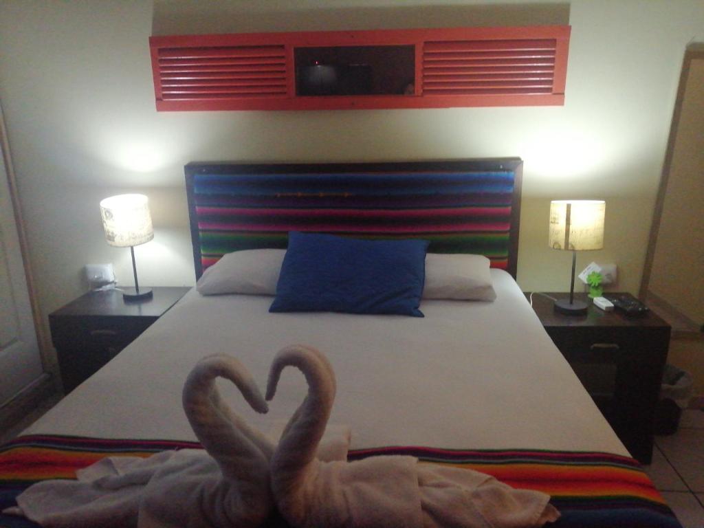 Antiguo CuscatlánHotel Antiguo的卧室里床边的两只天鹅