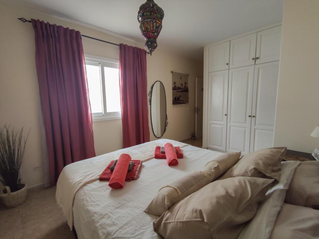 法马拉Casa Chinijo的一间卧室配有一张大床,上面有红色的毛巾