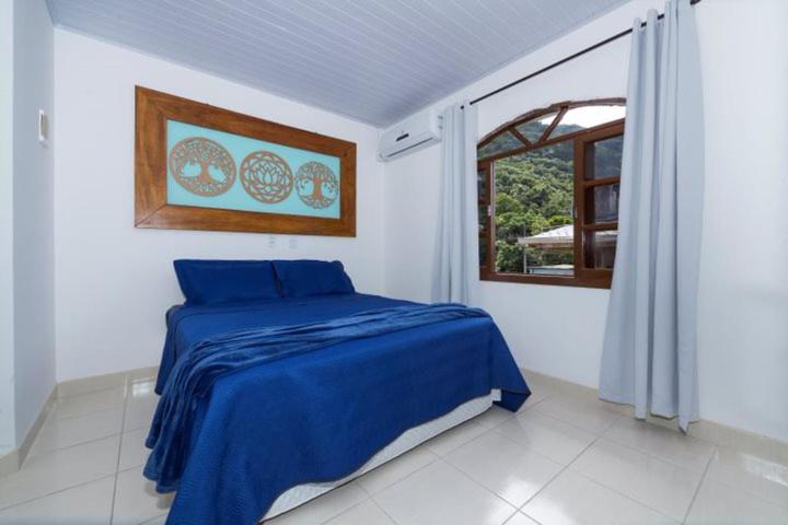 邦比尼亚斯Recanto da Conceição的一间卧室设有蓝色的床和窗户。
