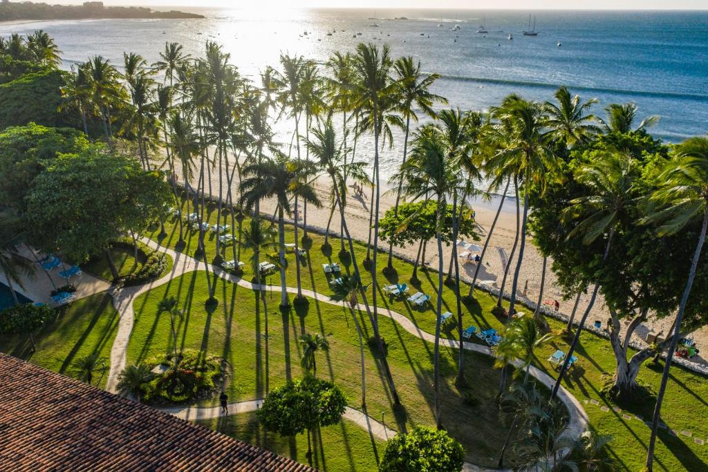 塔马林多Hotel Tamarindo Diria Beach Resort的享有海滩和棕榈树的空中景致