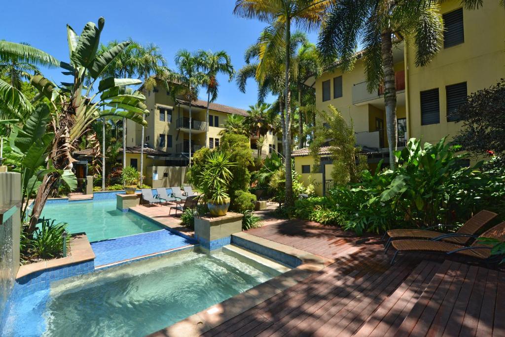 道格拉斯港礁石俱乐部度假酒店的棕榈树和建筑的度假游泳池