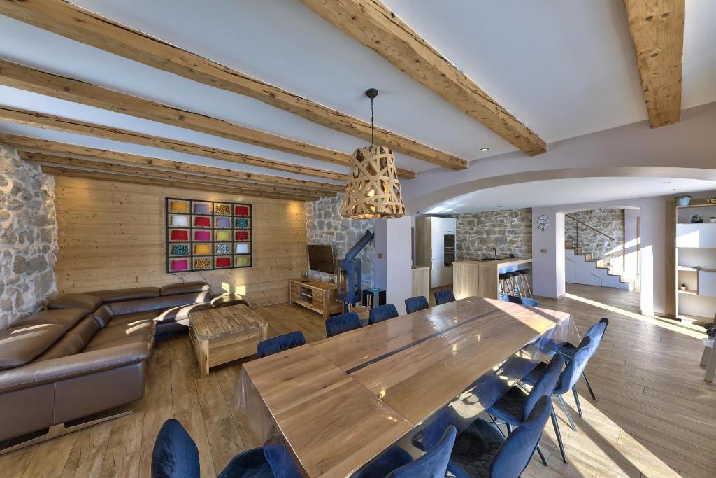 莱鲁斯Maison idéalement placée vue magnifique, départ ski de fond/Randonnée depuis le jardin的一间设有一张大木桌和蓝色椅子的用餐室