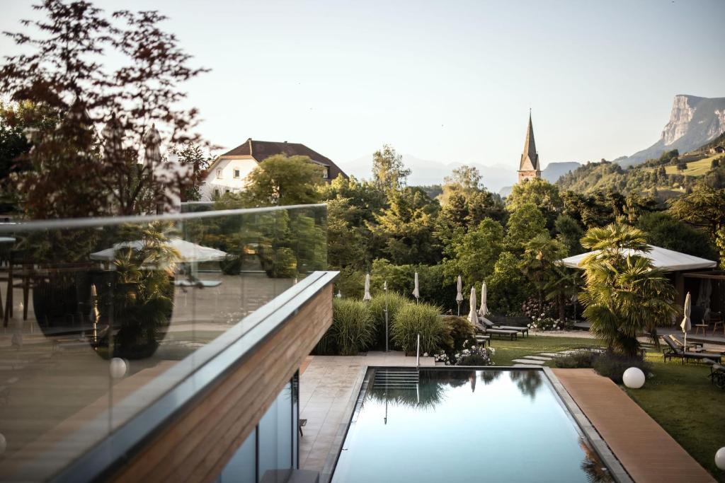 沃兰ALPIANA - green luxury Dolce Vita Hotel的一座带游泳池和花园的房屋