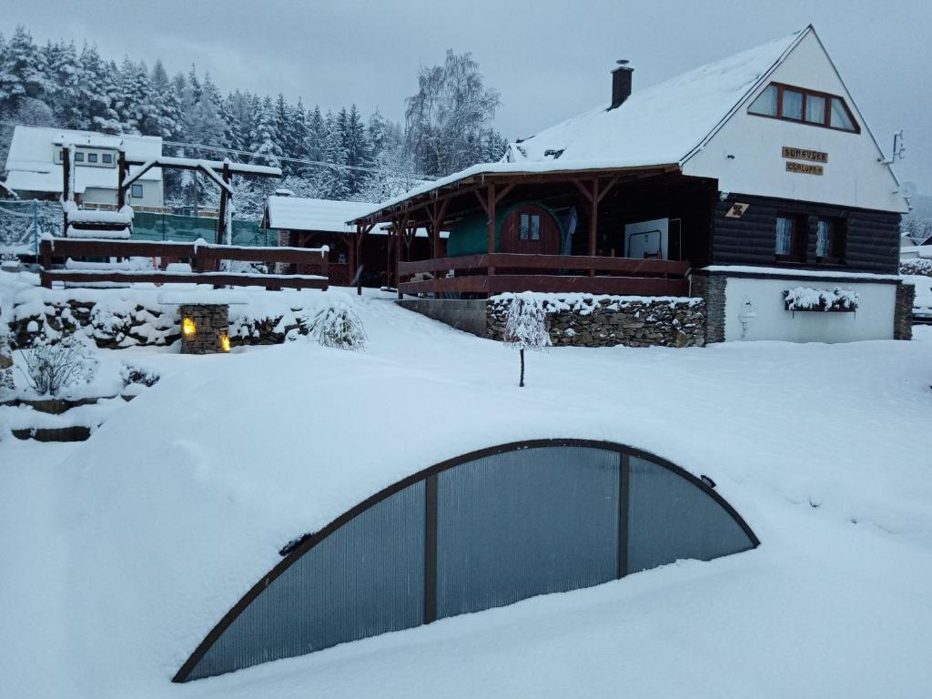 PohorskoŠumavská rekreační chalupa的一座有房子和建筑物的雪盖庭院