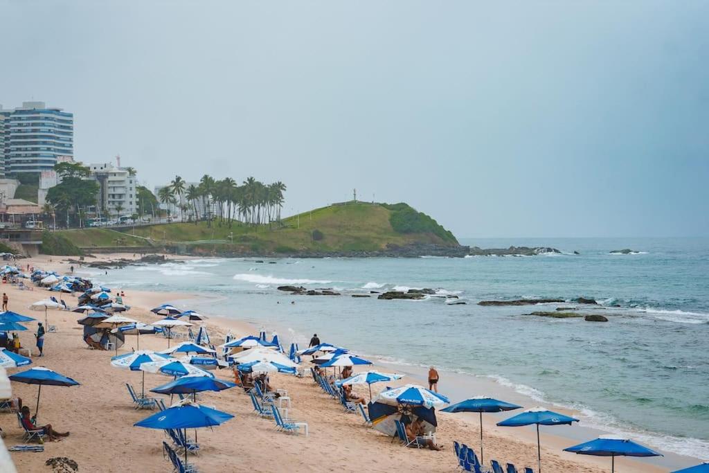 萨尔瓦多Apartamento Incrível的海滩上有许多蓝色的遮阳伞和人